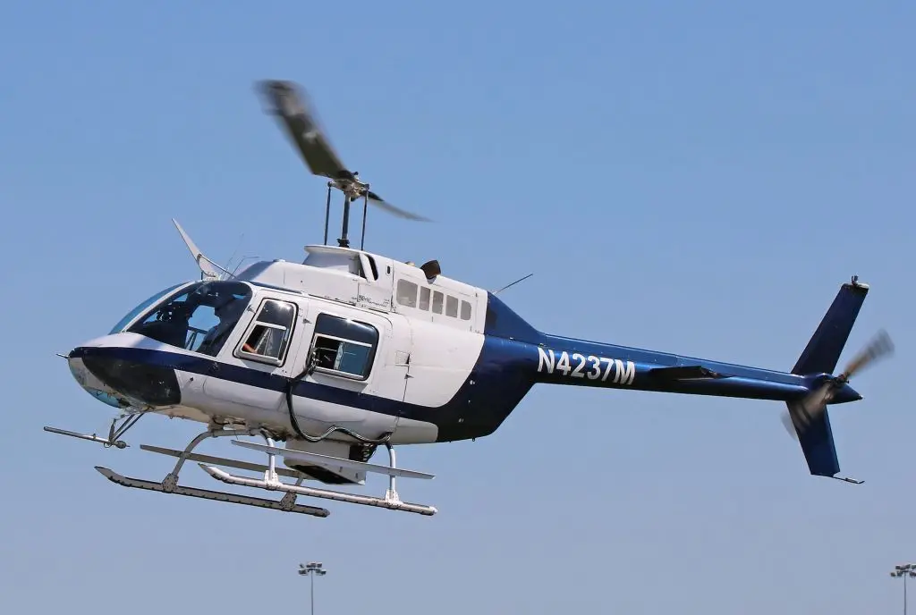 Bell 206 JetRange helicopter flying seen from the left